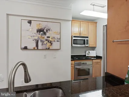 a kitchen with stainless steel appliances granite countertop a stove top oven a sink and dishwasher