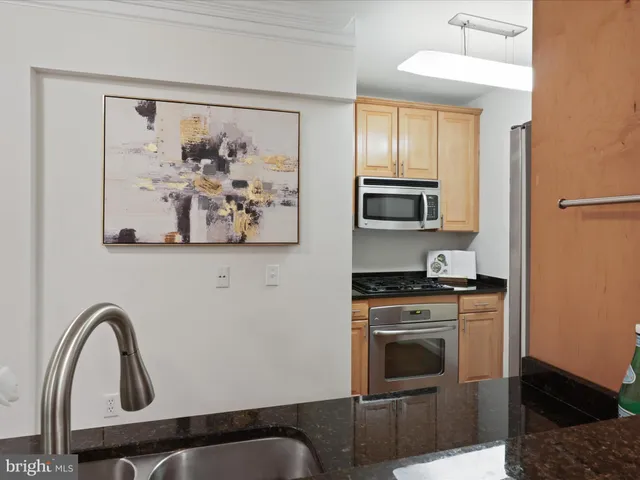 a kitchen with stainless steel appliances granite countertop a stove top oven a sink and dishwasher