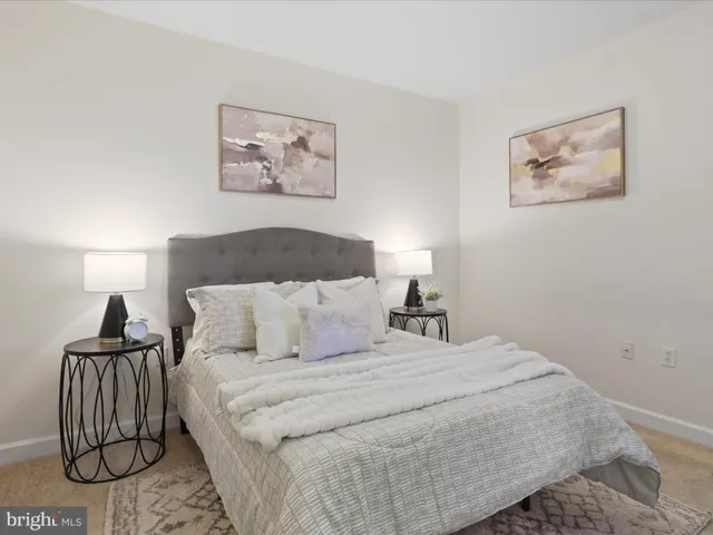 a bedroom with a bed and a painting on the wall