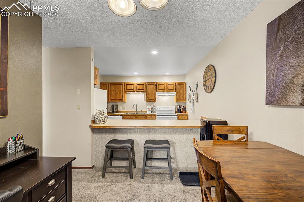 1140 Magic Lamp Way, Unit 3 Monument, CO 80132 - Photo 9 of 23 a room with a table chairs and a wooden floor