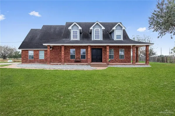 a front view of a house with yard and green space