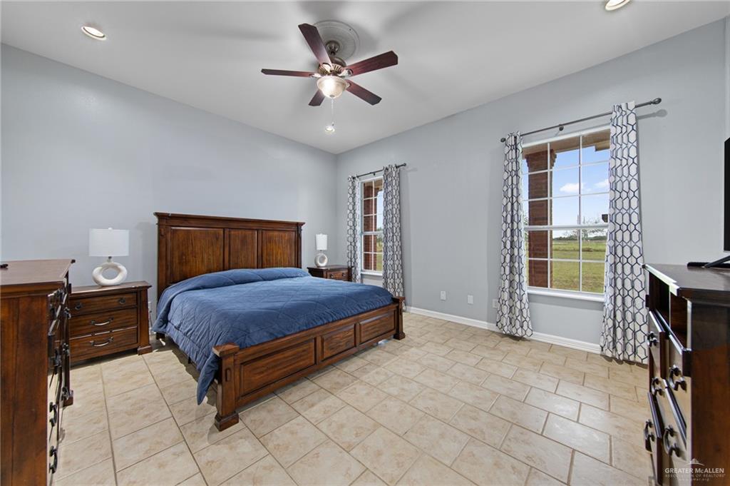15474 Primera Road Harlingen, TX 78552 - Photo 14 of 45 a bedroom with a bed and a chandelier