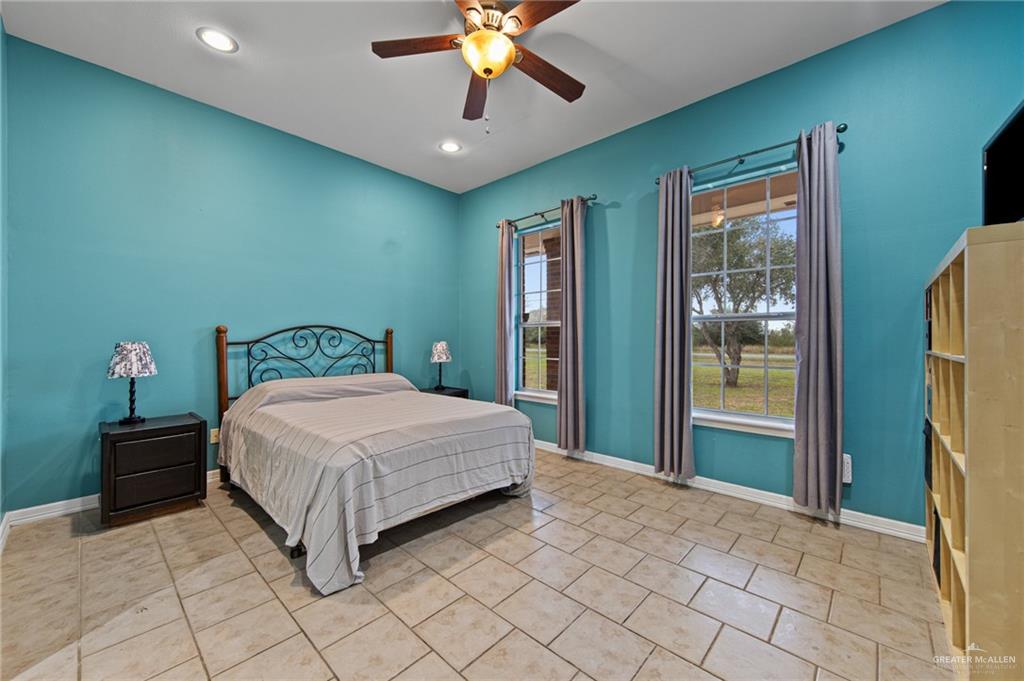 15474 Primera Road Harlingen, TX 78552 - Photo 20 of 45 a bedroom with a bed and a chandelier