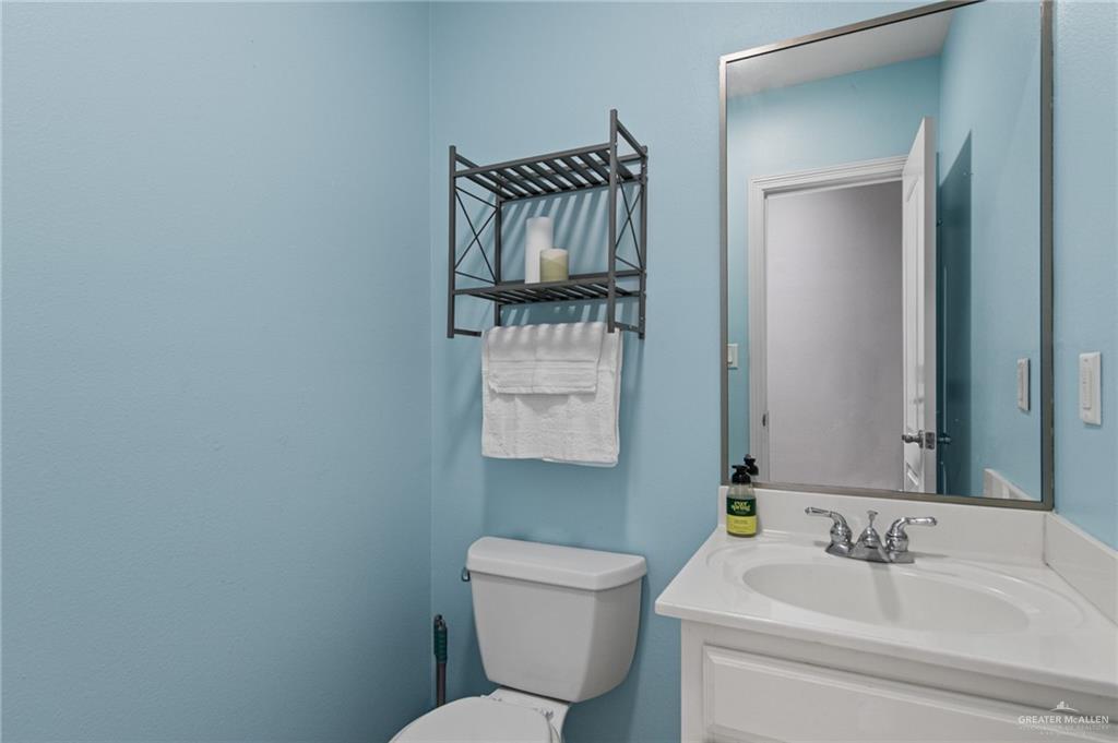 15474 Primera Road Harlingen, TX 78552 - Photo 24 of 45 a bathroom with a toilet sink and mirror