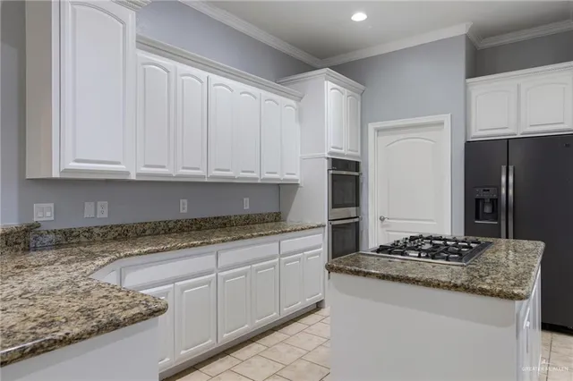 a kitchen with granite countertop stainless steel appliances white cabinets and a granite counter tops