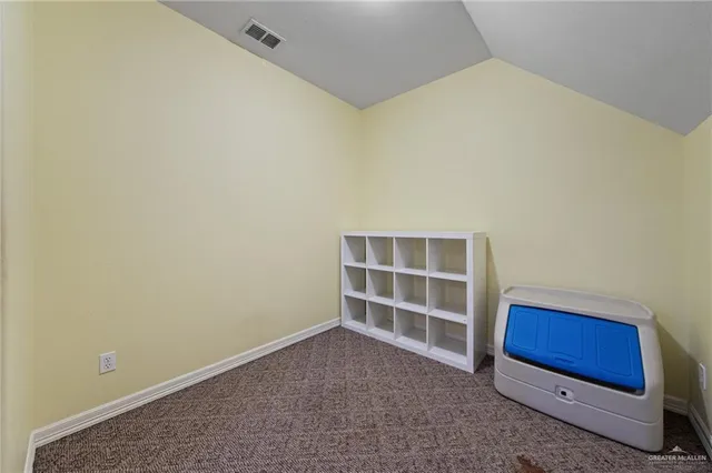 a view of an empty room with furniture and window