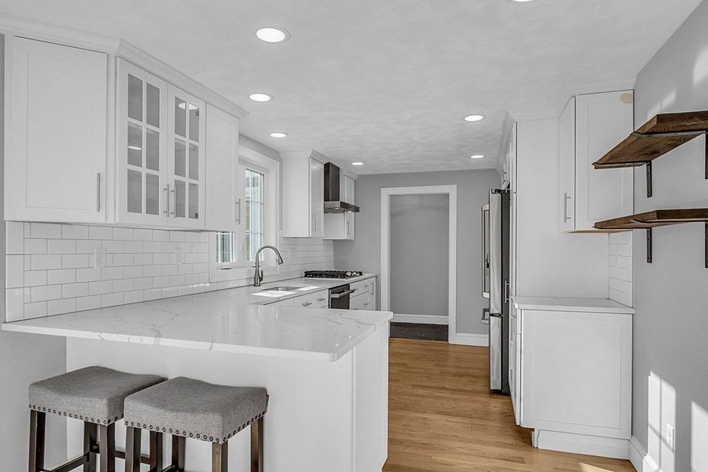 4 Radcliffe Road North Chelmsford, MA 01863 - Photo 11 of 40 a kitchen with kitchen island a stove a refrigerator and a sink with wooden cabinets