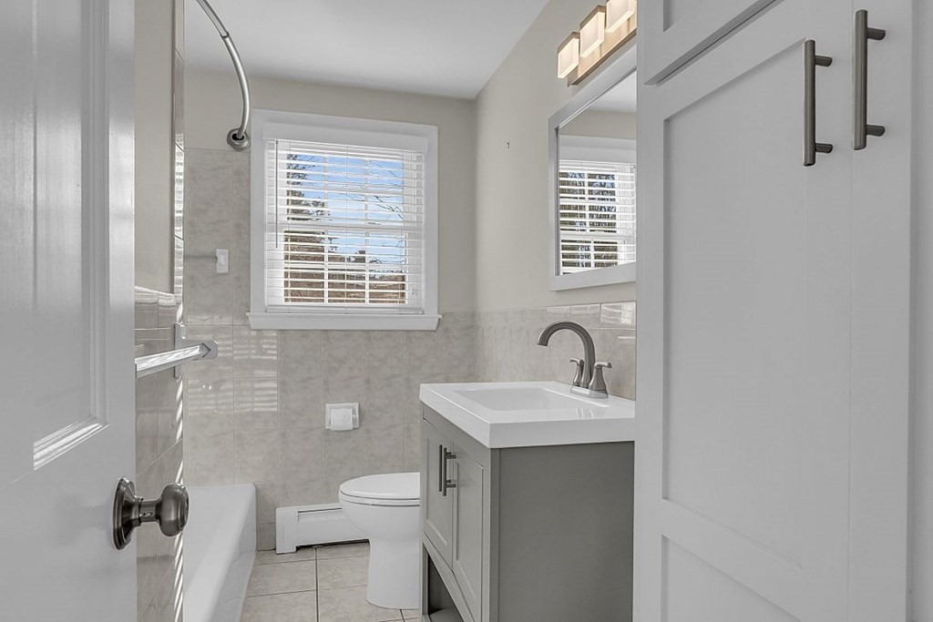 4 Radcliffe Road North Chelmsford, MA 01863 - Photo 22 of 40 a bathroom with a granite countertop sink toilet a mirror and shower