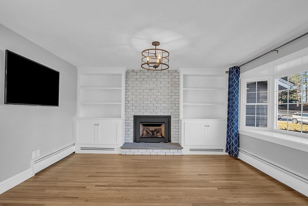 4 Radcliffe Road North Chelmsford, MA 01863 - Photo 8 of 40 a living room with a fireplace and a flat screen tv