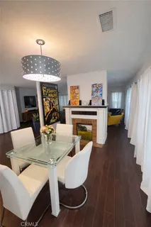 a dining room with furniture a chandelier and wooden floor