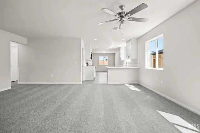 a view of a livingroom with a ceiling fan a ceiling fan and a window