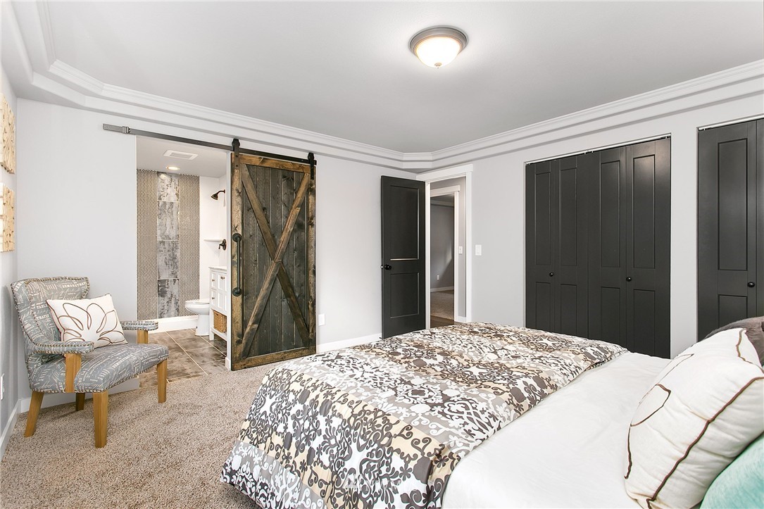 23028 35th Avenue Southeast Bothell, WA 98021 - Photo 14 of 25 a bedroom with a bed and a chandelier