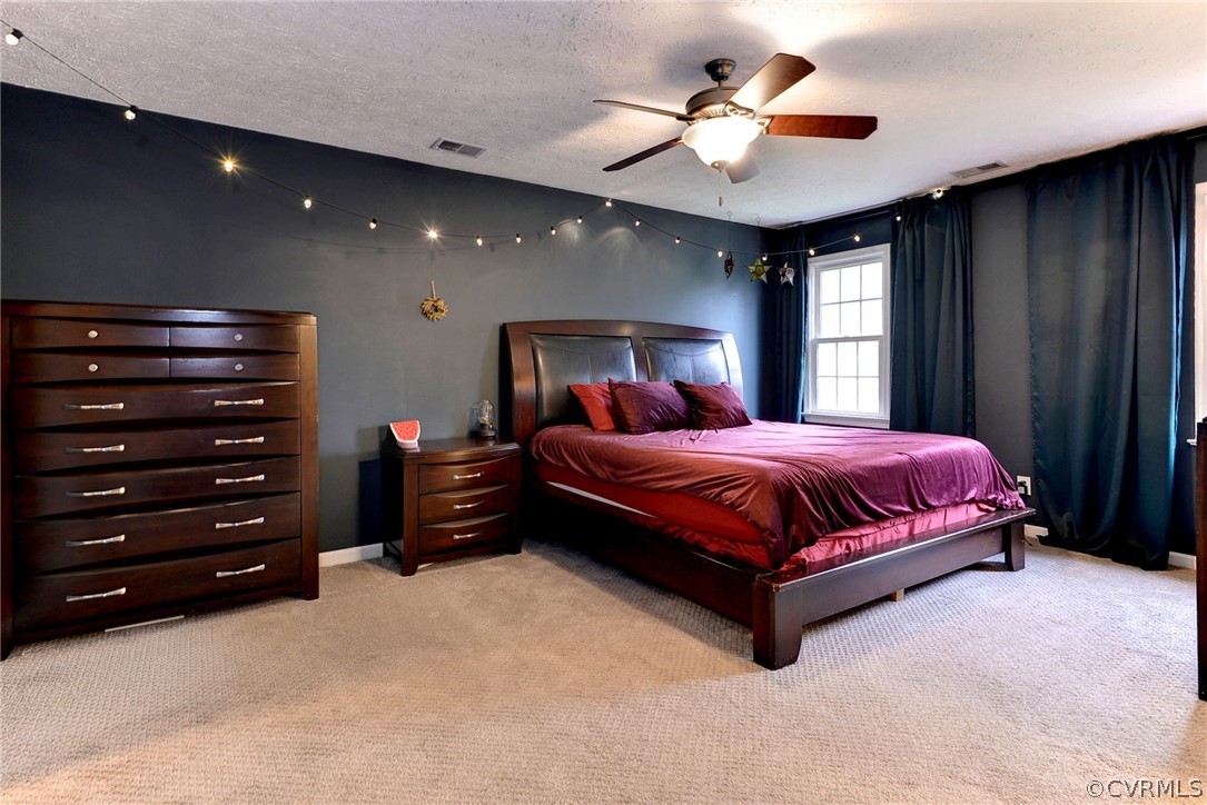 8416 Down Patrick Way Williamsburg, VA 23188 - Photo 24 of 47 a spacious bedroom with a bed and a chandelier