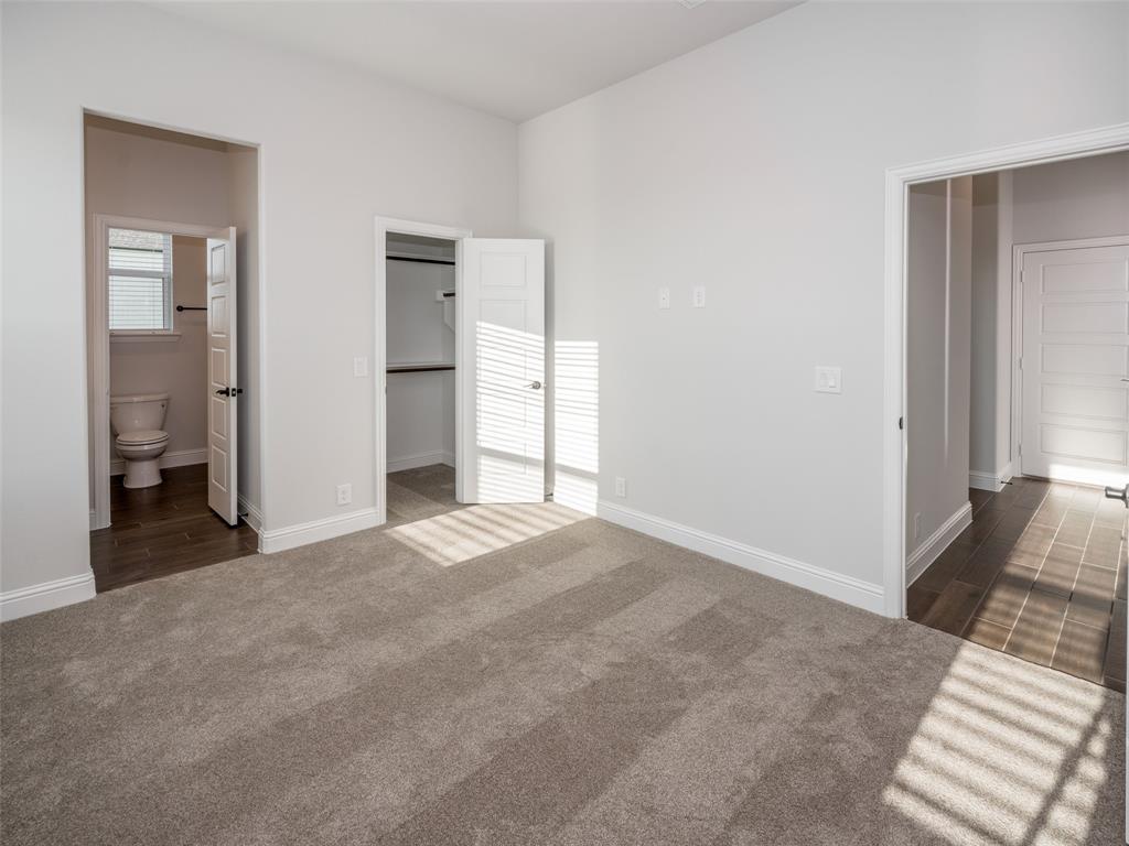2108 Charters Circle Nevada, TX 75173 - Photo 27 of 37 Unfurnished bedroom featuring a spacious closet, dark carpet, and ensuite bathroom