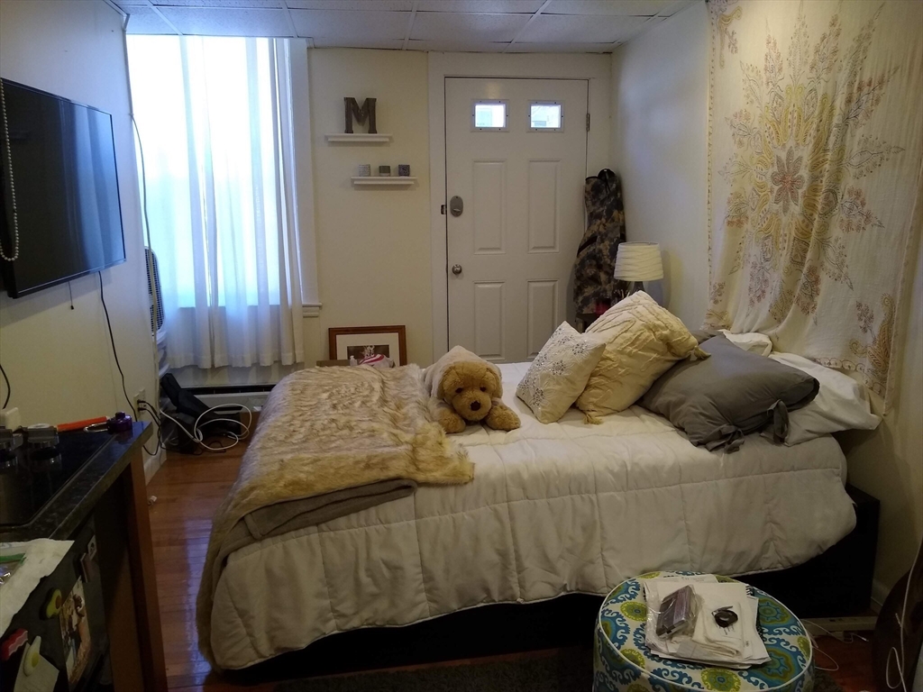 507 Beacon Street, Unit C Boston, MA 02215 - Photo 4 of 5 a bedroom with a bed and a flat tv screen