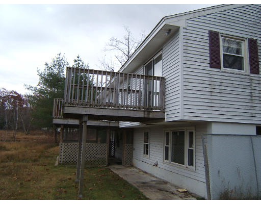 276 Pommogussett Road Rutland, MA 01543 - Photo 5 of 20 a view of a house with a small deck and wooden fence
