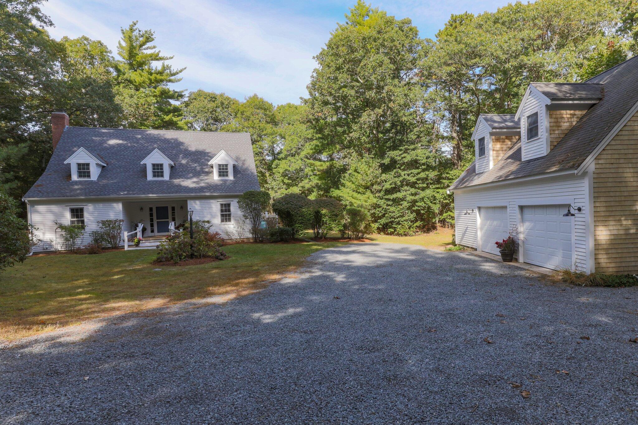 a front view of house with yard and trees in the background