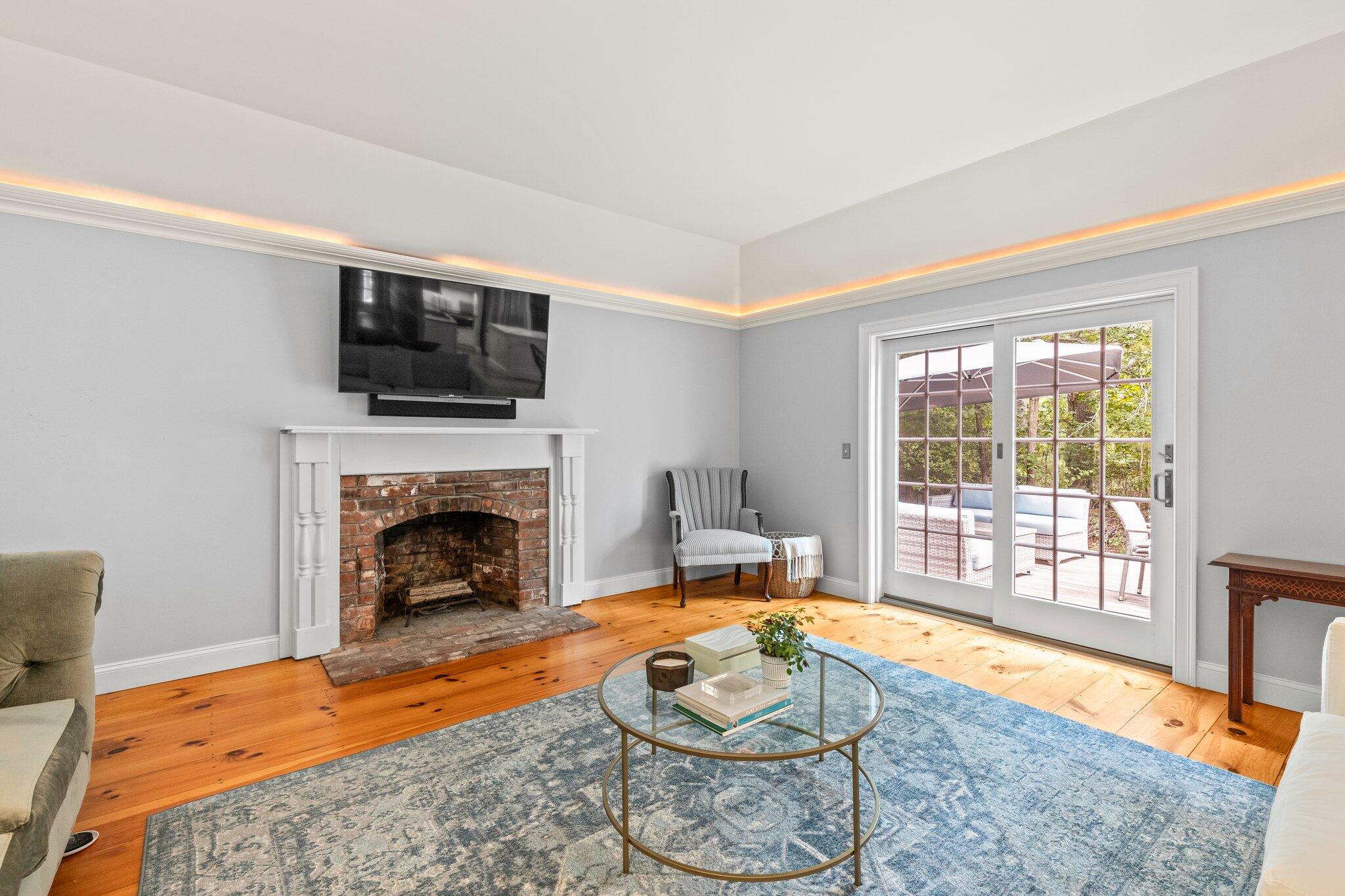 1756 Osterville West Barnstable Road West Barnstable, MA 02668 - Photo 22 of 62 a living room with furniture a flat screen tv and a fireplace