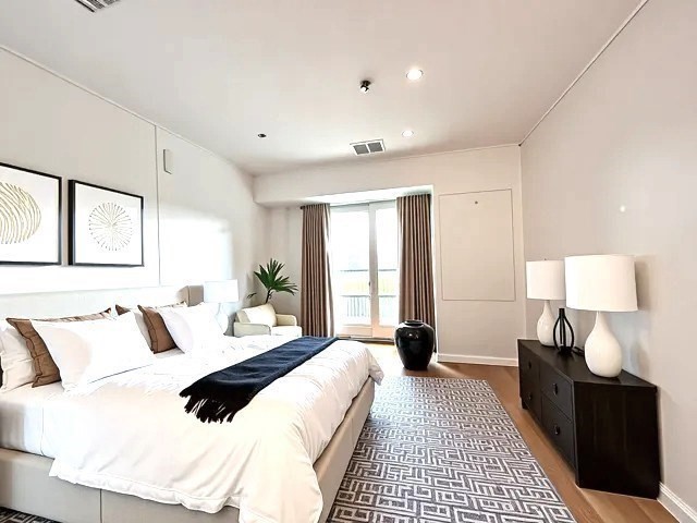 133 Commander Shea Boulevard, Unit 502 Quincy, MA 02171 - Photo 2 of 8 a bedroom with a bed and a lamp