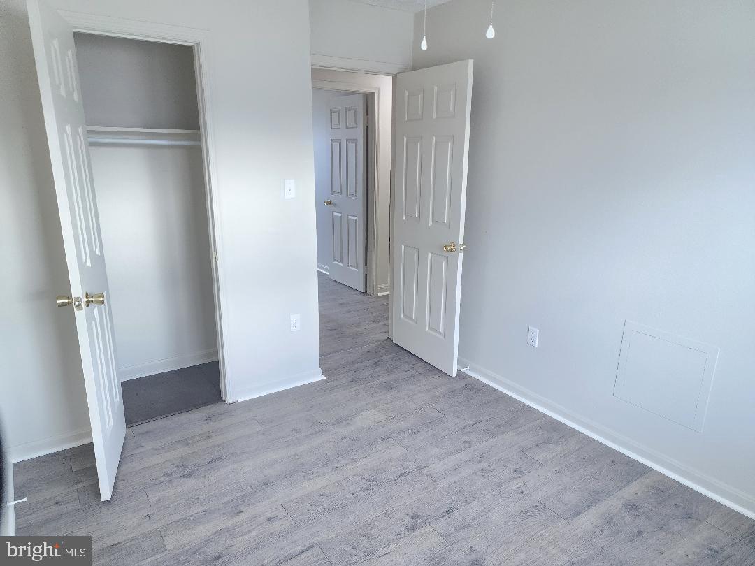 130-134 West 13th Street, Unit 134 Front Royal, VA 22630 - Photo 18 of 21 a view of an empty room with wooden floor and a hallway