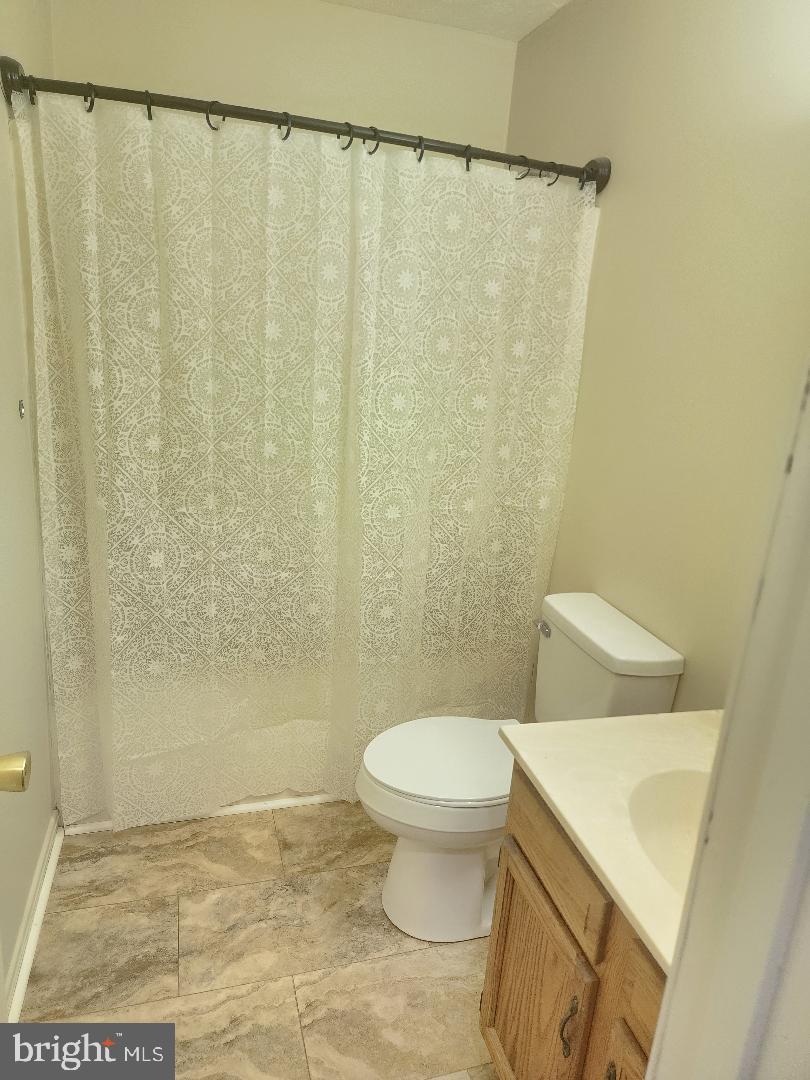 130-134 West 13th Street, Unit 134 Front Royal, VA 22630 - Photo 9 of 21 a white toilet sitting next to a shower curtain