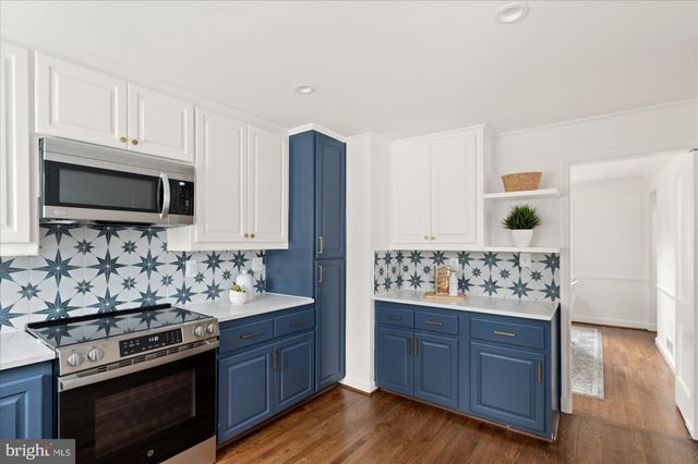 a kitchen with stainless steel appliances granite countertop a stove and a wooden cabinets