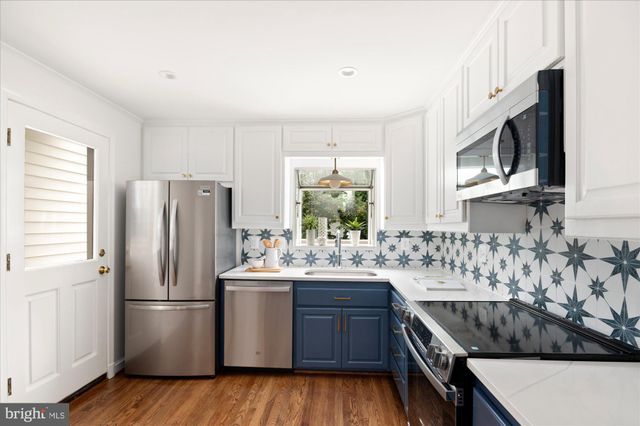 a kitchen with stainless steel appliances granite countertop a refrigerator stove a sink and dishwasher with wooden floor