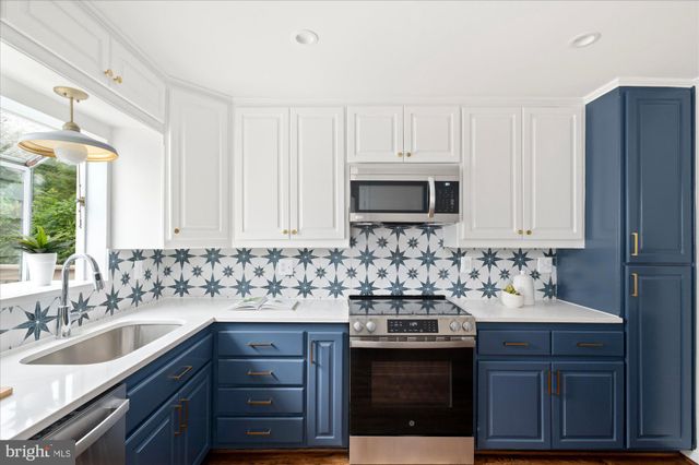 a kitchen with sink a stove and microwave