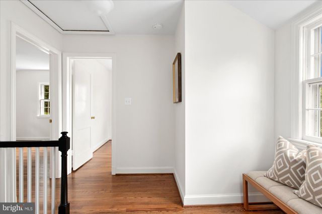 a view of a hallway with wooden floor and a window