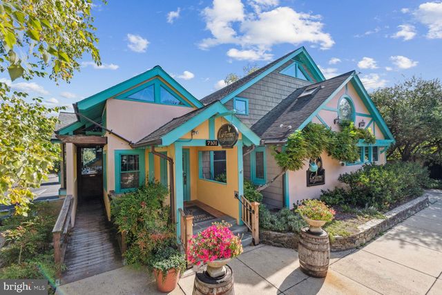 a front view of house along with deck and outdoor seating