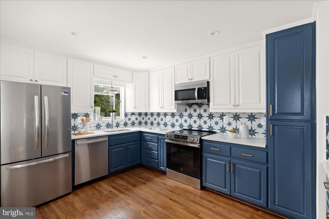 a kitchen with stainless steel appliances granite countertop a stove a sink dishwasher a refrigerator and a stove top oven