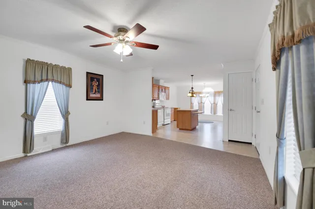 a view of a livingroom with a ceiling fan and window