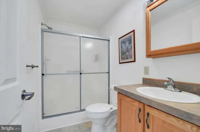 a bathroom with a granite countertop toilet sink and mirror
