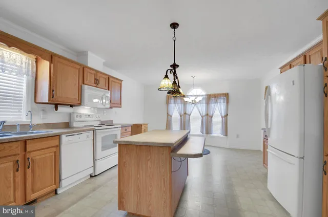 a kitchen with stainless steel appliances granite countertop a refrigerator a sink dishwasher a oven with white cabinets and wooden floor