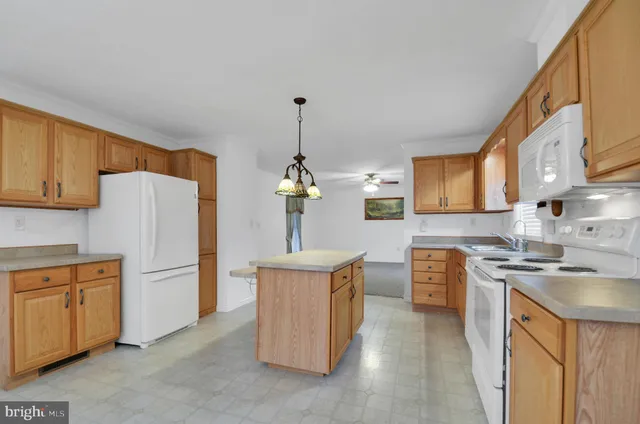 a kitchen with stainless steel appliances granite countertop a stove top oven a refrigerator a sink dishwasher and white cabinets with wooden floor