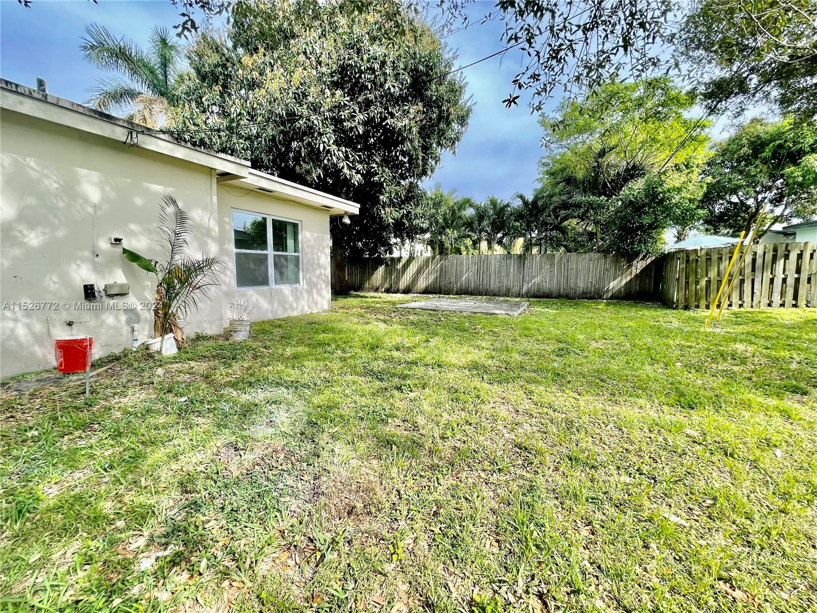 215 Southwest 10th Street Hallandale Beach, FL 33009 - Photo 14 of 18 a backyard of a house with table and chairs