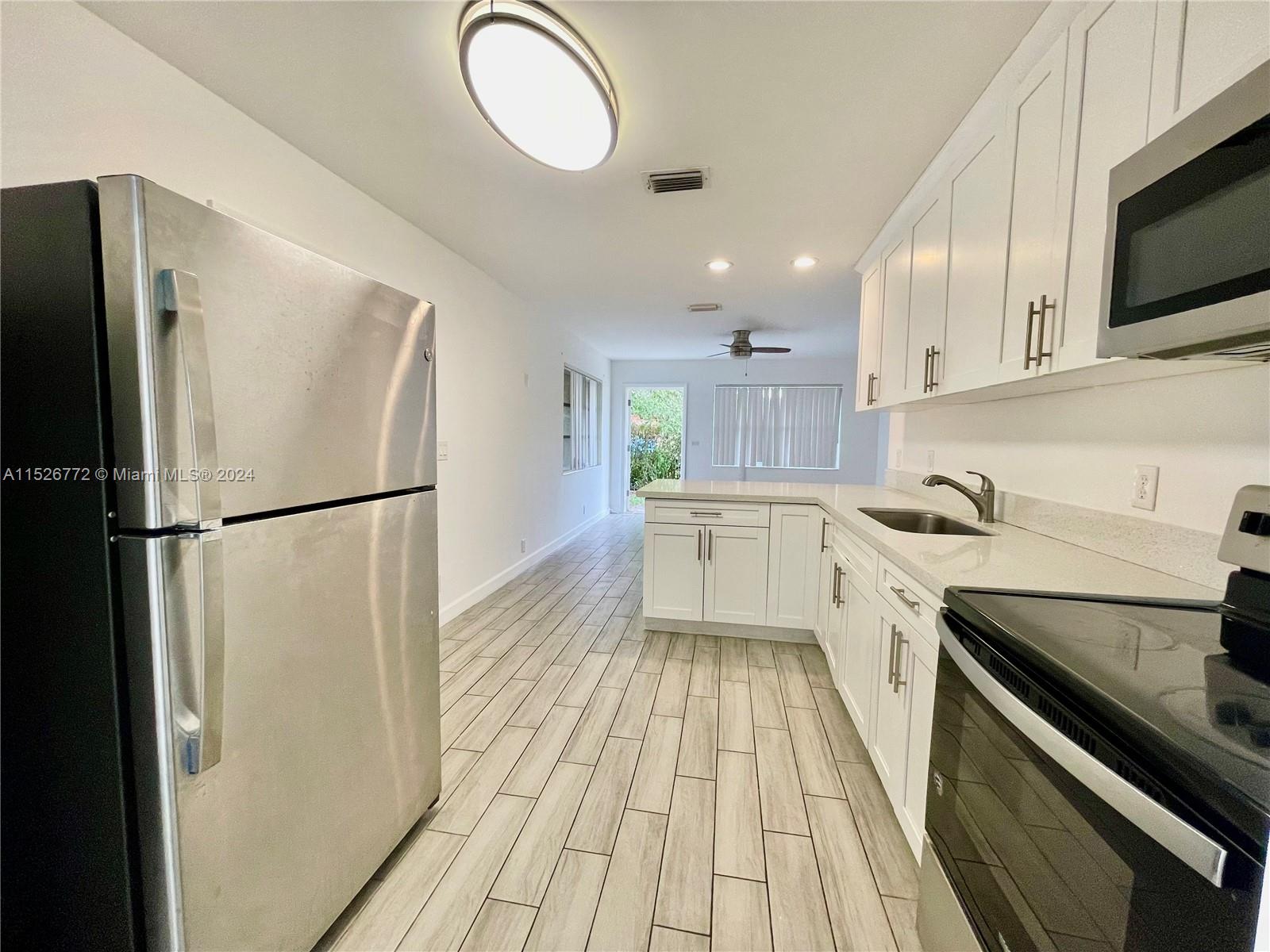 215 Southwest 10th Street Hallandale Beach, FL 33009 - Photo 2 of 18 a kitchen with a refrigerator and a sink