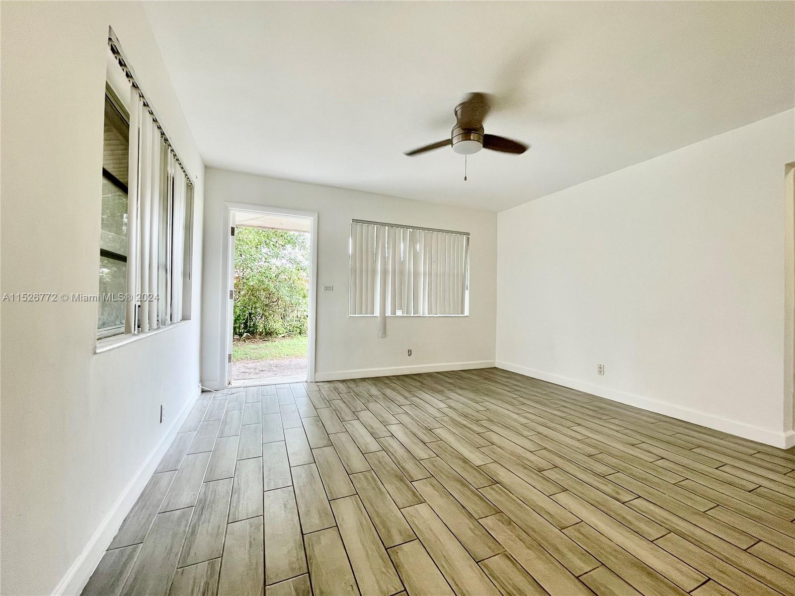 215 Southwest 10th Street Hallandale Beach, FL 33009 - Photo 6 of 18 a view of an empty room with wooden floor and a window