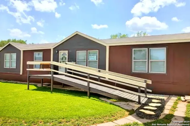 a backyard of a house with table and chairs