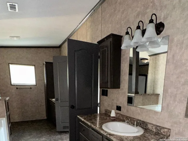 a bathroom with a granite countertop sink a mirror and shower view