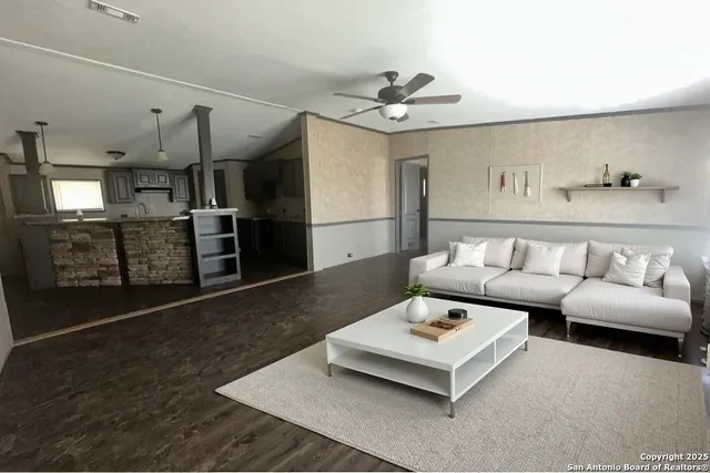 a living room with furniture and kitchen view