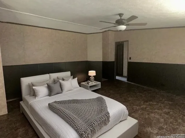 a bed room with a bed and a ceiling fan