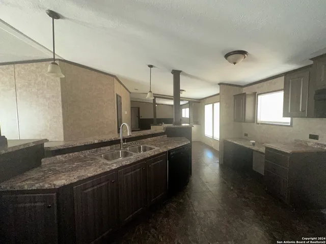 a kitchen with stainless steel appliances granite countertop a sink a stove and a wooden floors