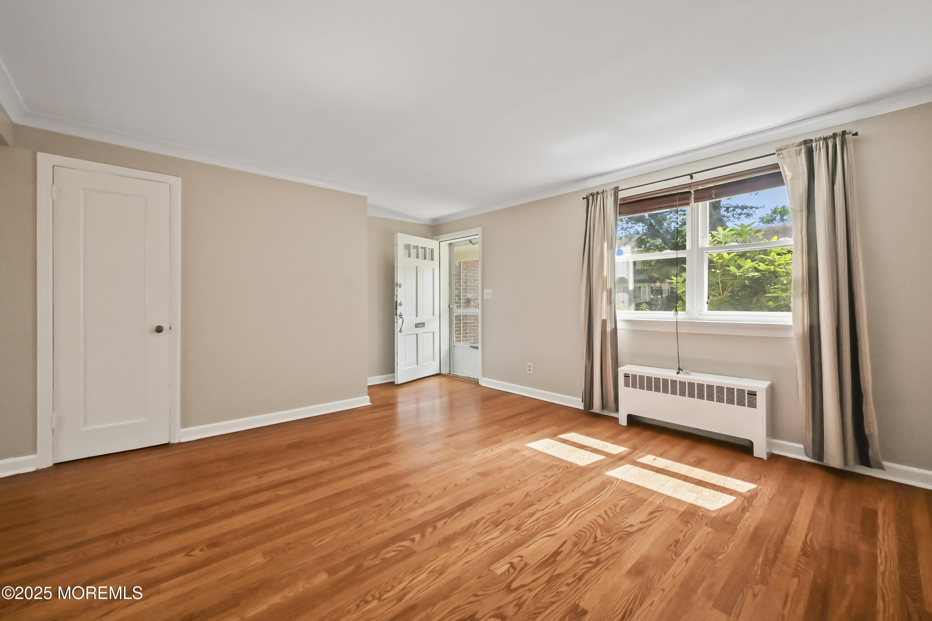 82 Manor Drive, Unit 803 Red Bank, NJ 07701 - Photo 6 of 19 a view of an empty room with wooden floor and a window