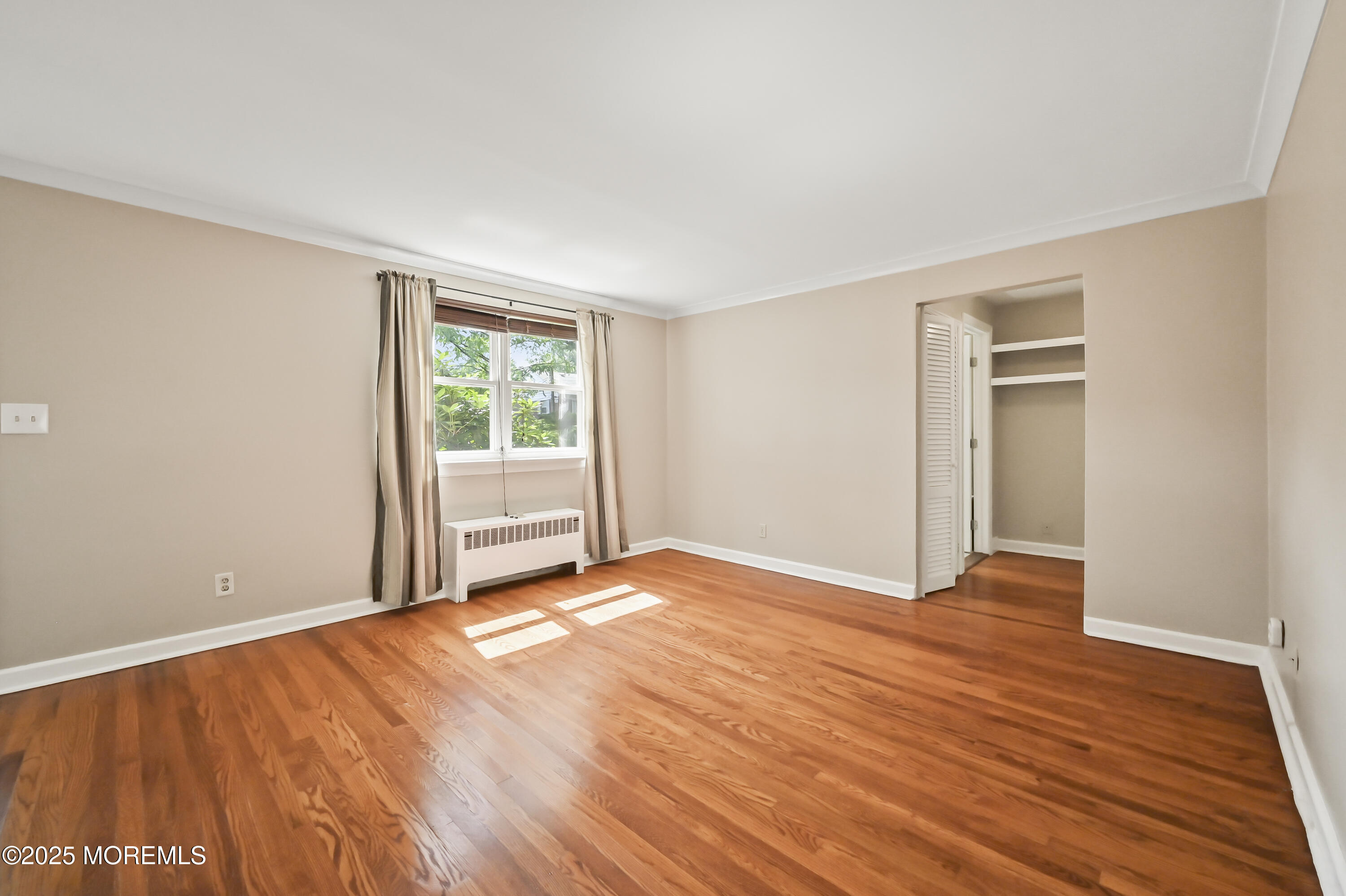 82 Manor Drive, Unit 803 Red Bank, NJ 07701 - Photo 7 of 19 a view of an empty room with wooden floor and a window