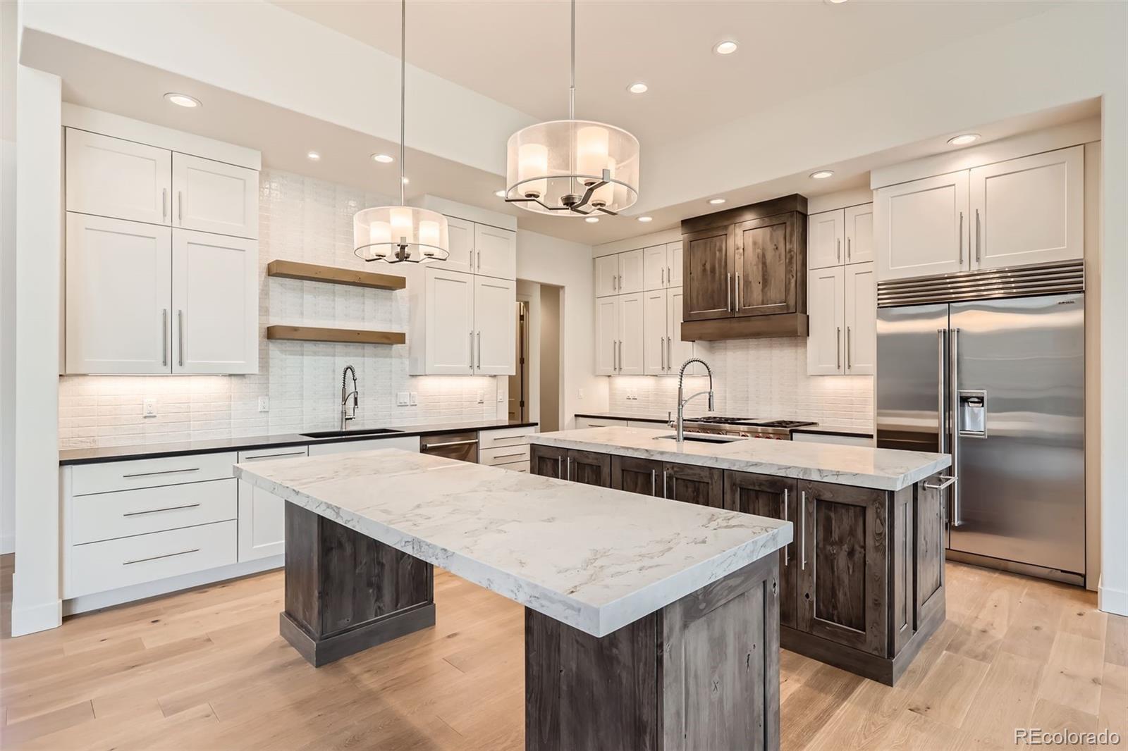 5841 Powell Road Parker, CO 80134 - Photo 11 of 50 a kitchen with a center island white cabinets and stainless steel appliances
