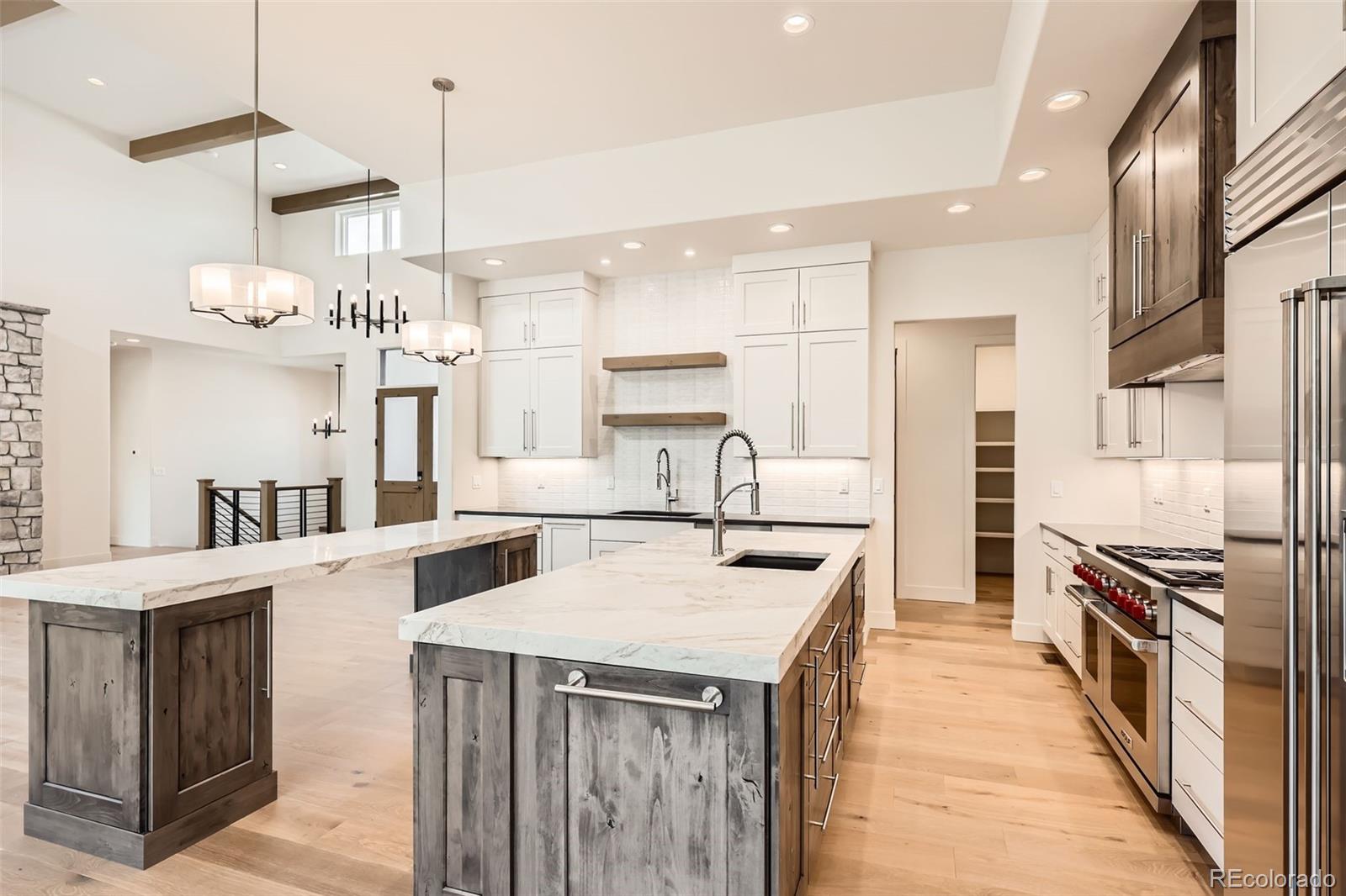 5841 Powell Road Parker, CO 80134 - Photo 12 of 50 a kitchen with a stove a refrigerator a oven and a sink with wooden floor