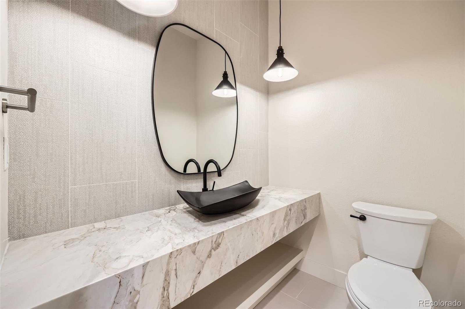 5841 Powell Road Parker, CO 80134 - Photo 16 of 50 a bathroom with a granite countertop sink a toilet and a mirror