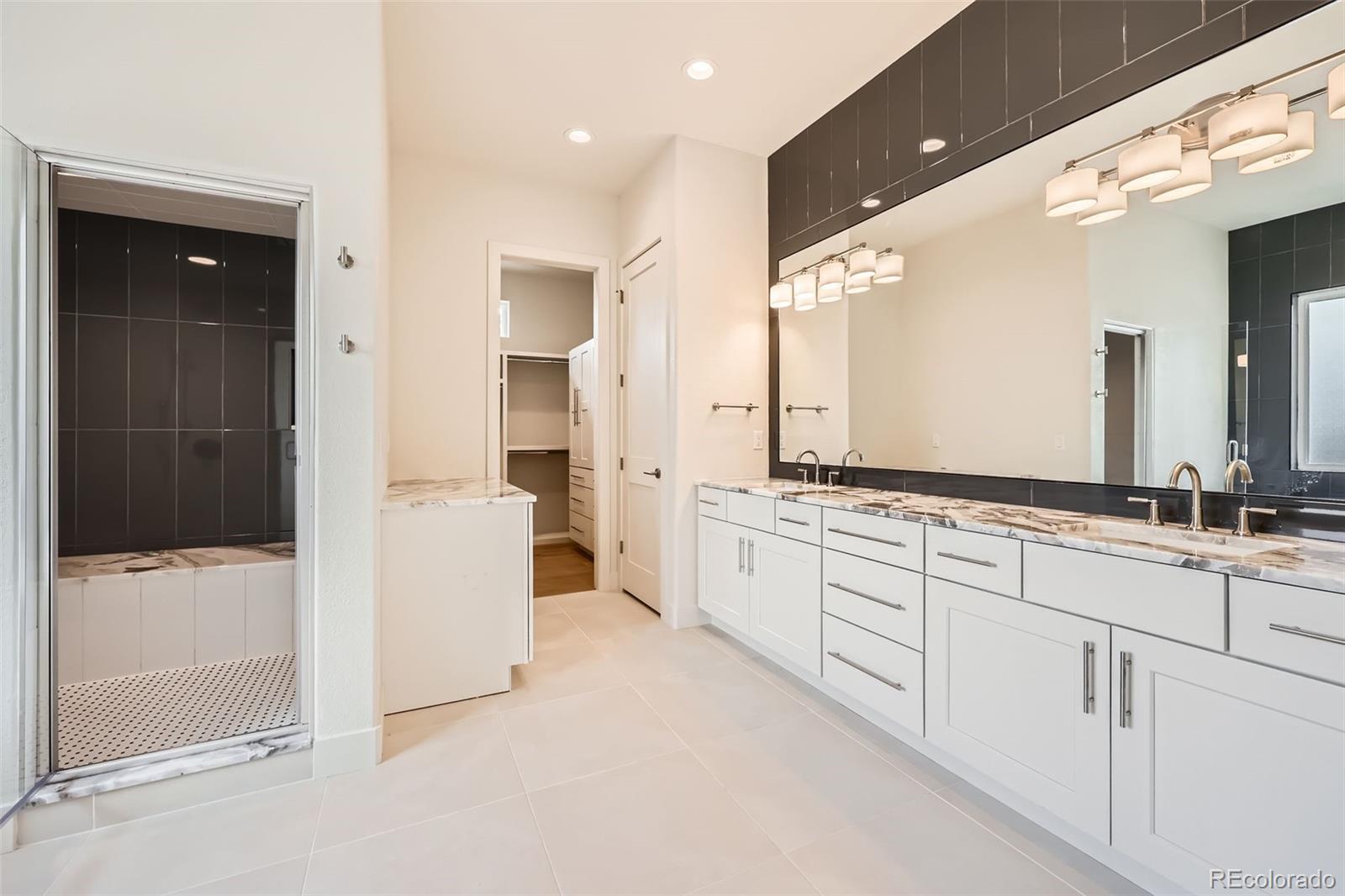 5841 Powell Road Parker, CO 80134 - Photo 20 of 50 a large bathroom with a glass door shower sink and mirror