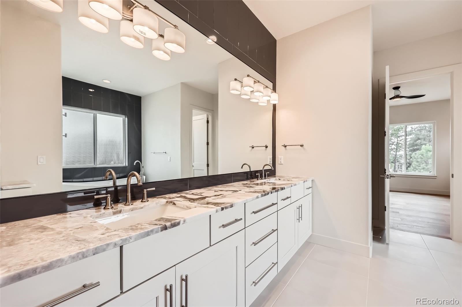 5841 Powell Road Parker, CO 80134 - Photo 21 of 50 a bathroom with a sink vanity granite and a mirror